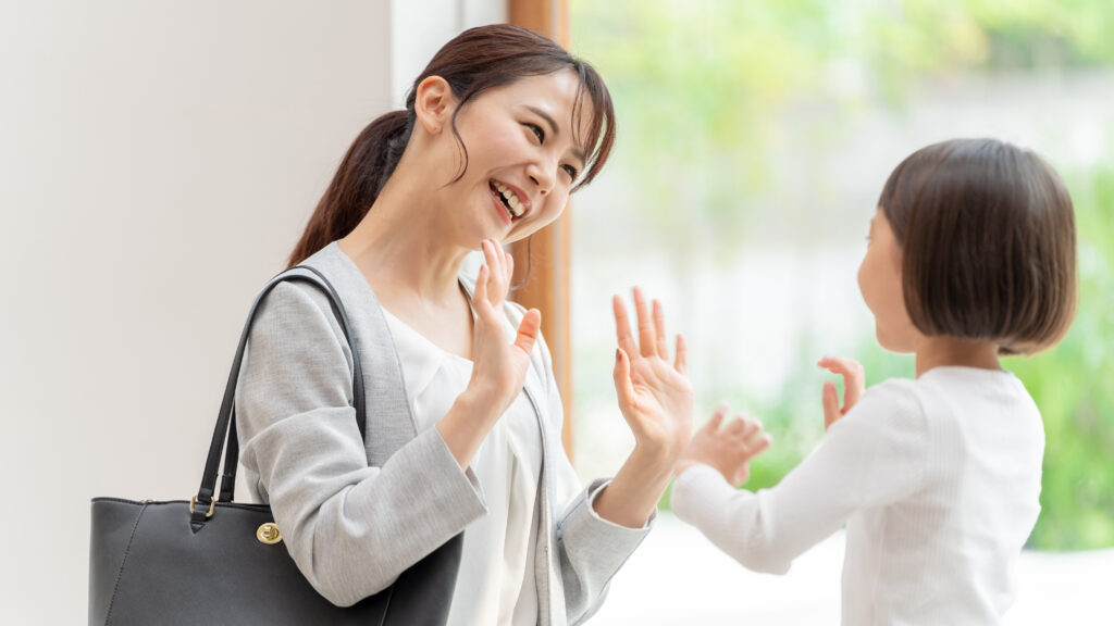 笑顔でバイバイする親子