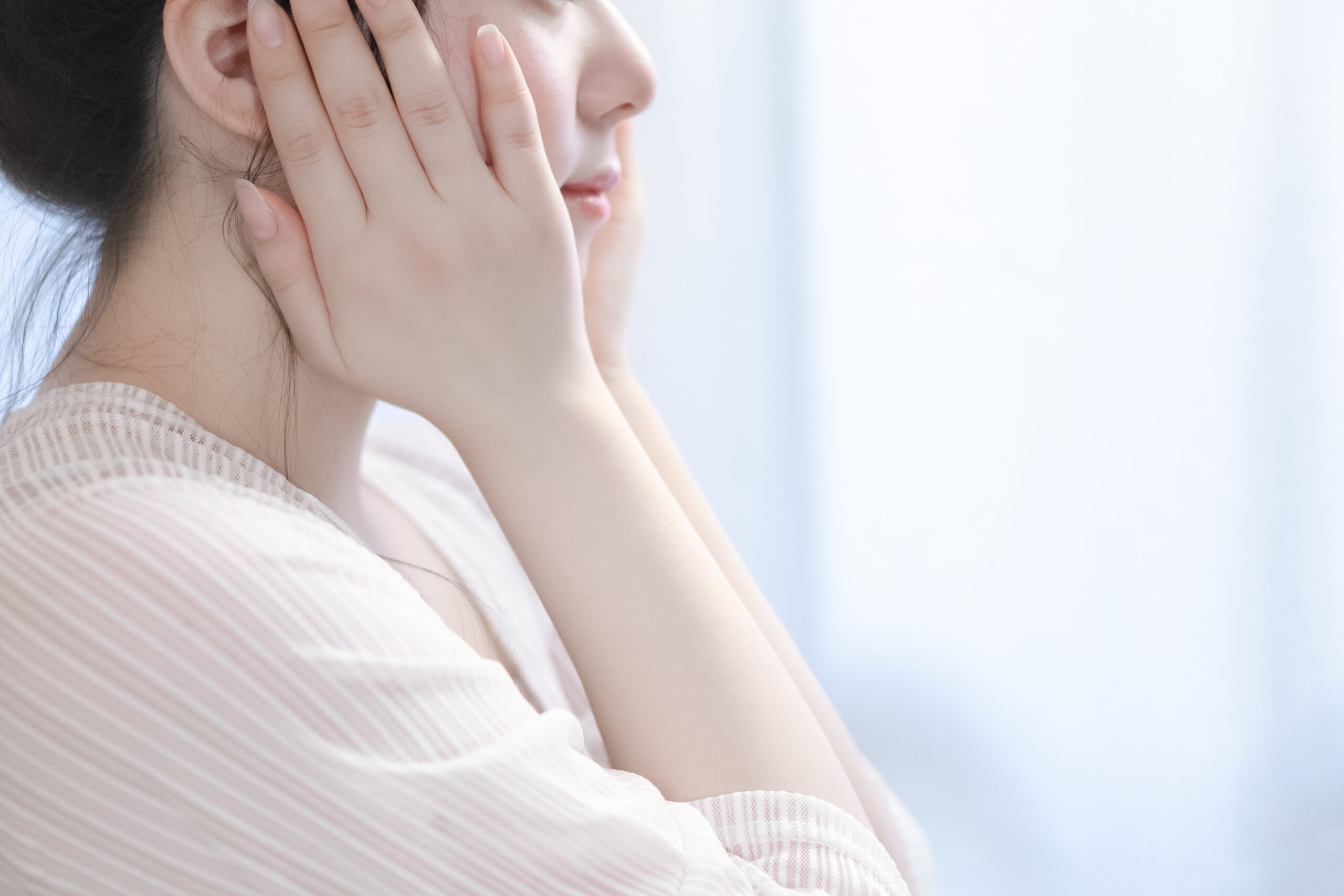 両手を頬に当てる女性